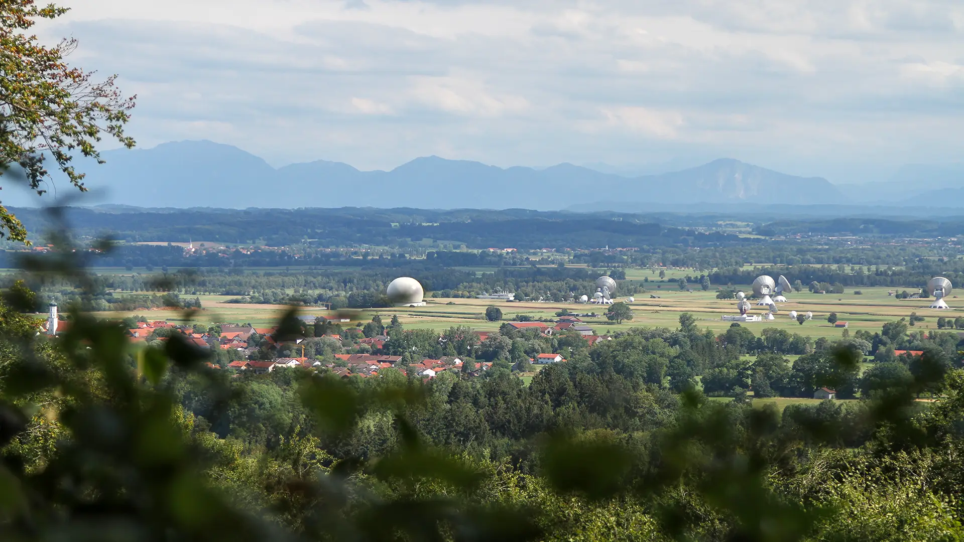 Wo Technik auf Naturschönheit trifft: Am Parabolgelände von Raisting haben sich einheimisch gewordene Störche niedergelassen – ein Ort, an dem sich Föhnpanorama und bayerische Tradition seit über 1.000 Jahren begegnen. Beste Reisezeit: ganzjährig, besonders reizvoll bei Föhnlage