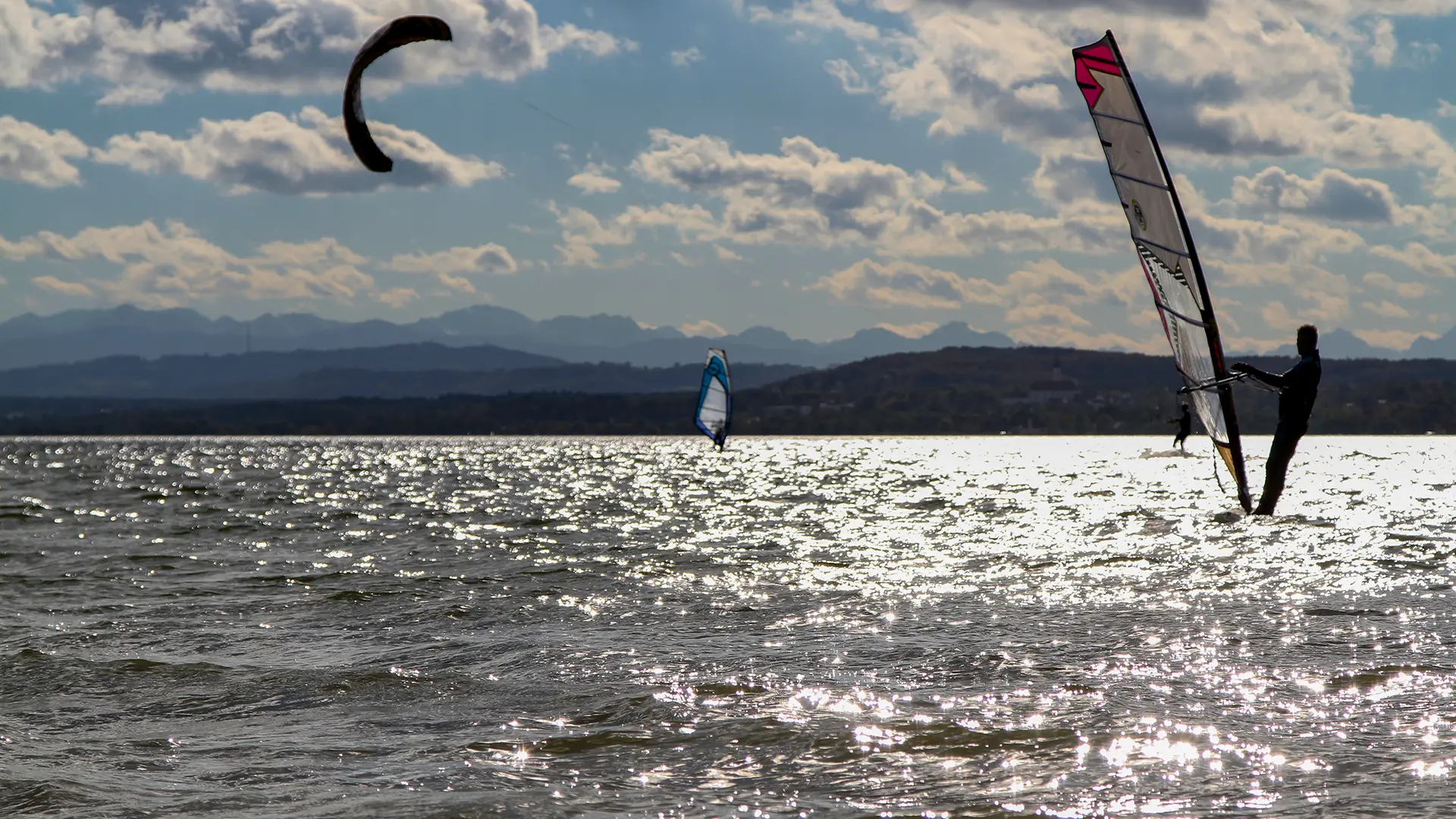 fuenfseen-kitesurfen-herrsching-ammersee-c-birgitmwidmann kiter am ammersee auf glitzernder Wasseroberfläche