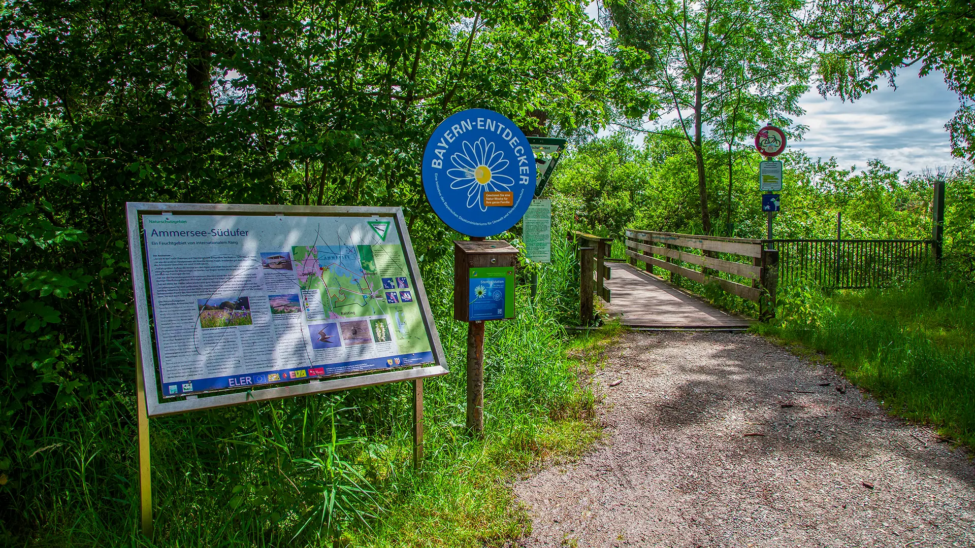 Naturschutzgebiet Diessen am Ammersee mit Holzbrückenwanderweg und Hinweistafel
