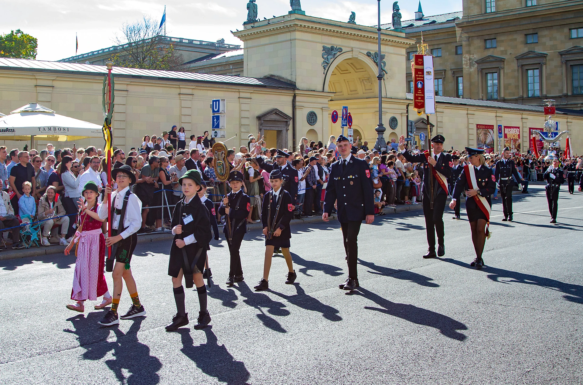 Taferlträger in Tracht und dunklen Capes gehen vor der Abordnung der Freiwilligen Feuerwehr München, Trachten- und Schützenzug München