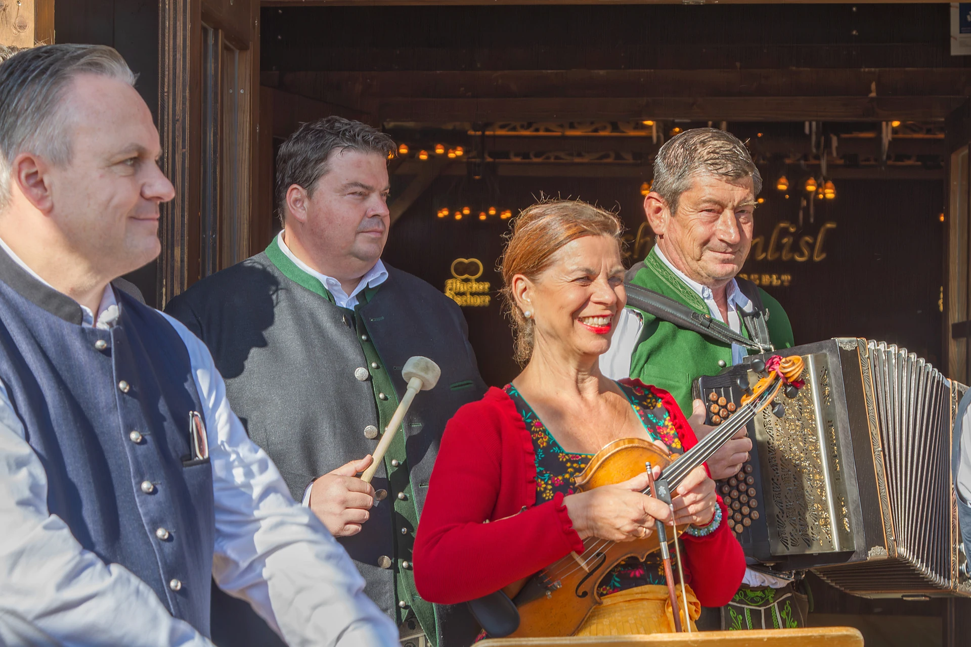 Traudi Siferlinger mit Geige zwischen Wiesnchef Christian Scharpf und zwei der drei neuen Schützenlisl-Wirte vor dem Volkssängerzelt auf der Oidn Wiesn, Oktoberfest München