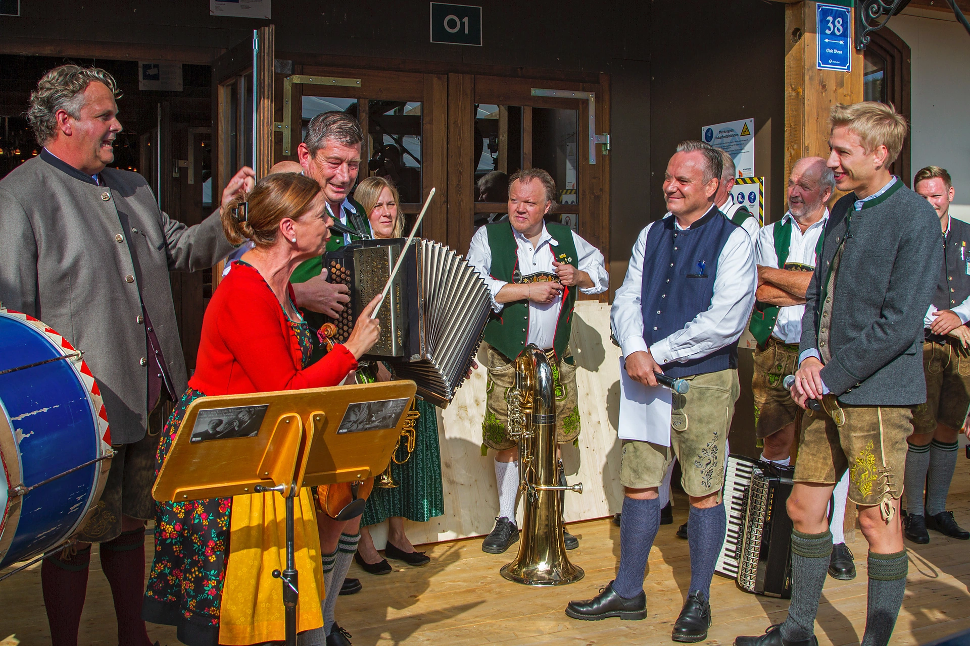 Musikerinnen und Musiker in Tracht mit Steirischer Harmonika, Tuba und Trommel spielen vor dem Volkssängerzelt Schützenlisl auf der Oidn Wiesn, Oktoberfest München