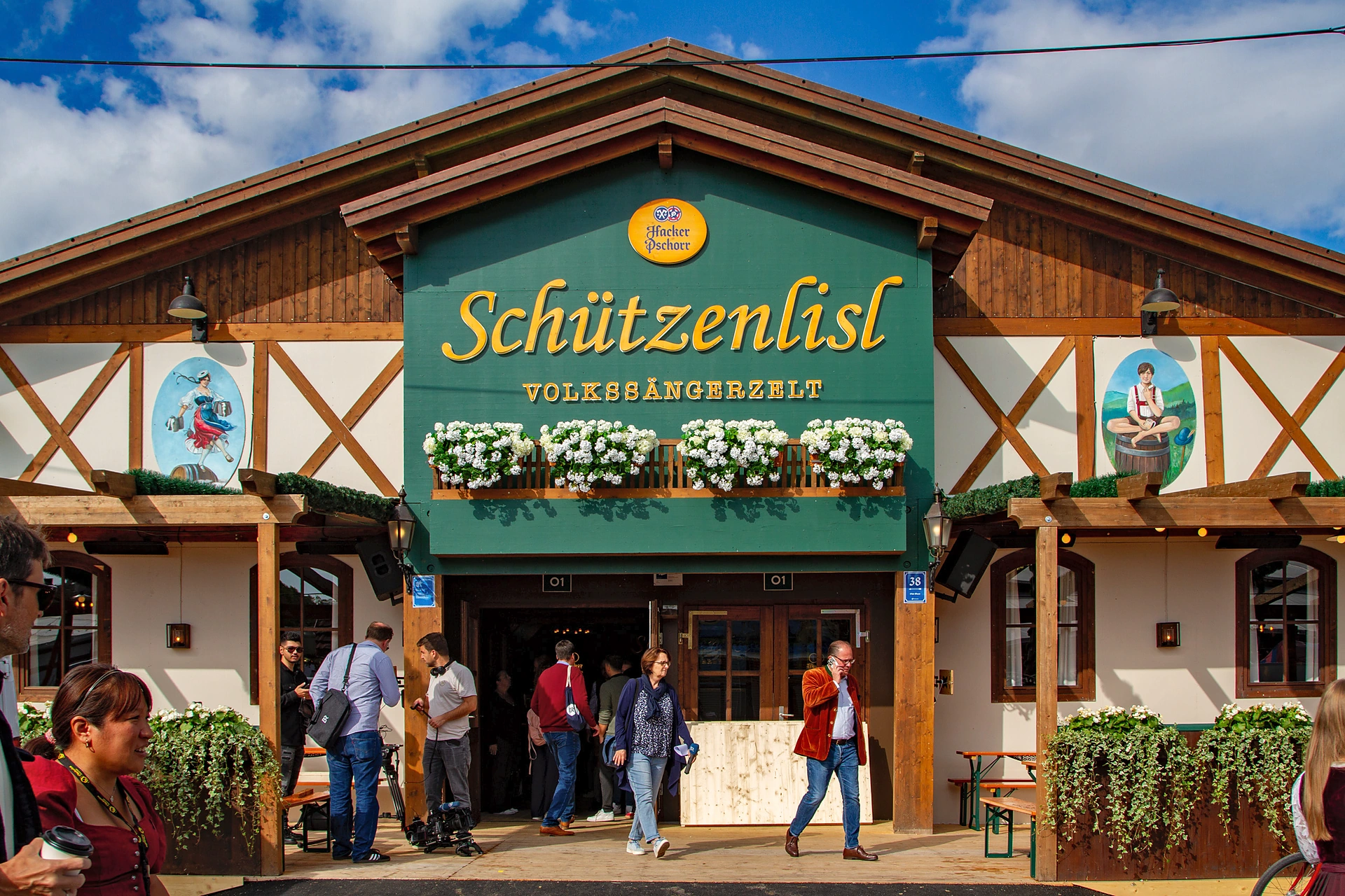 Grün-weiße Giebelfassade des Volkssängerzelts Schützenlisl mit Blumenkästen und gemalten Figuren auf der Oidn Wiesn, Oktoberfest München