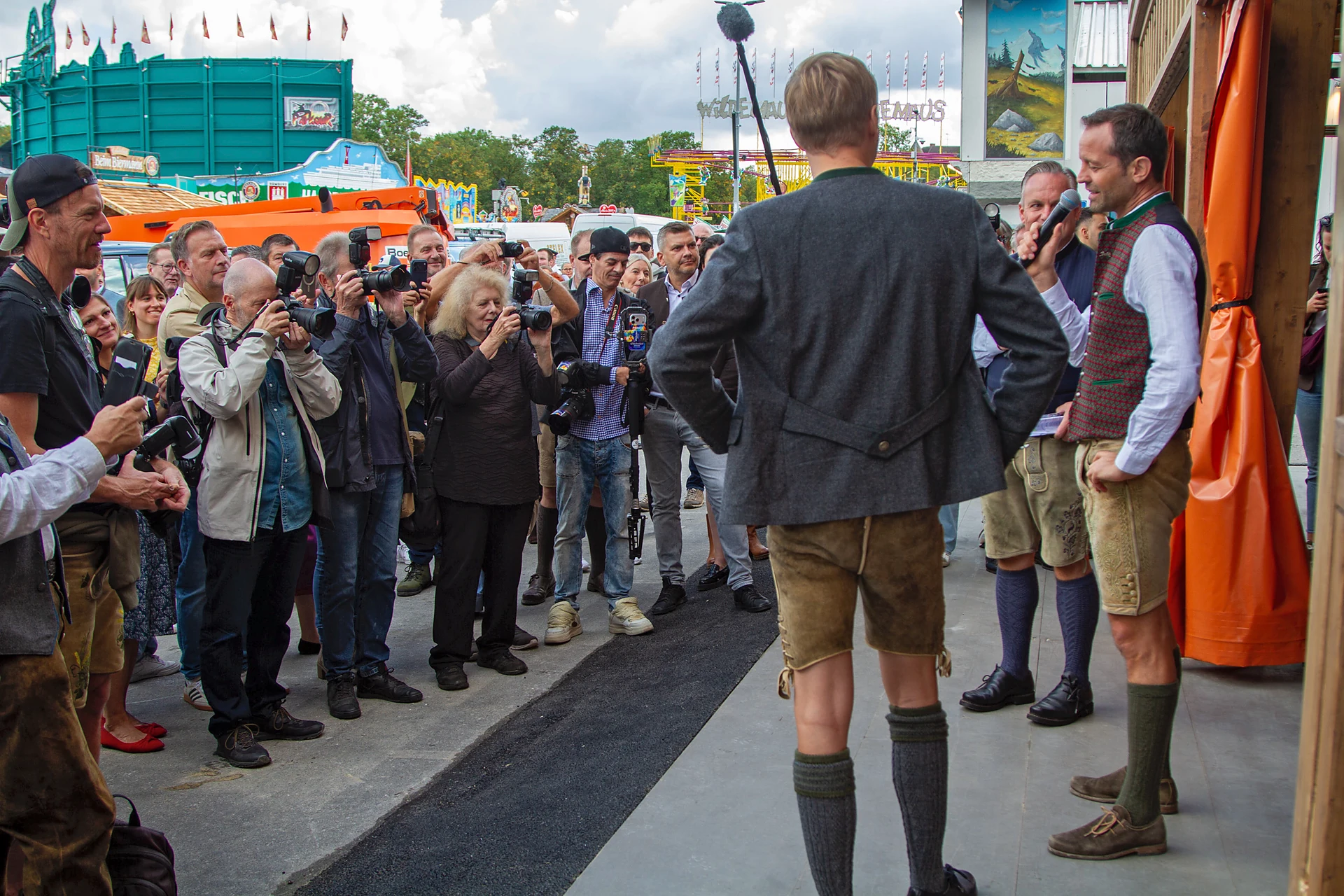 Pressefotografen stehen in einer Reihe vor Bodos Cafézelt, rechts Festwirt Otto Lindinger, daneben Wiesnchef Christian Scharpf mit dem Mikrofon vor dem Gesicht, im Vordergrund von hinten Oberbürgermeister Dominik Krause, Oktoberfest München. *PersonInImage:* Otto Lindinger, Christian Scharpf