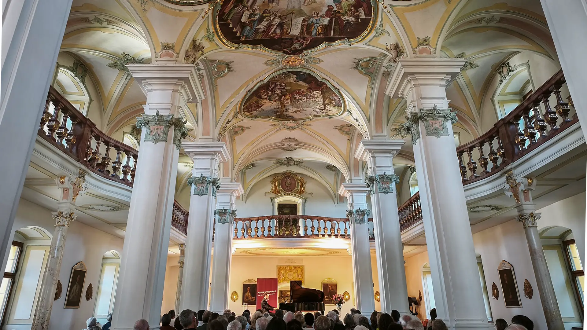 Biblothekssaal Polling beim Konzert Obermeier von PODIUM MUSICALE e.V. Säulensaal mit Zuschauer und beleuchteter Bühne